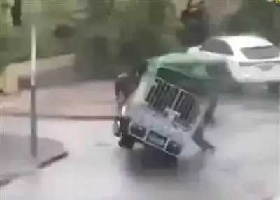 ▲周荣在台风中扶车,被压身亡。 网传视频截图 ▲周荣在台风中扶车,被压身亡。 网传视频截图